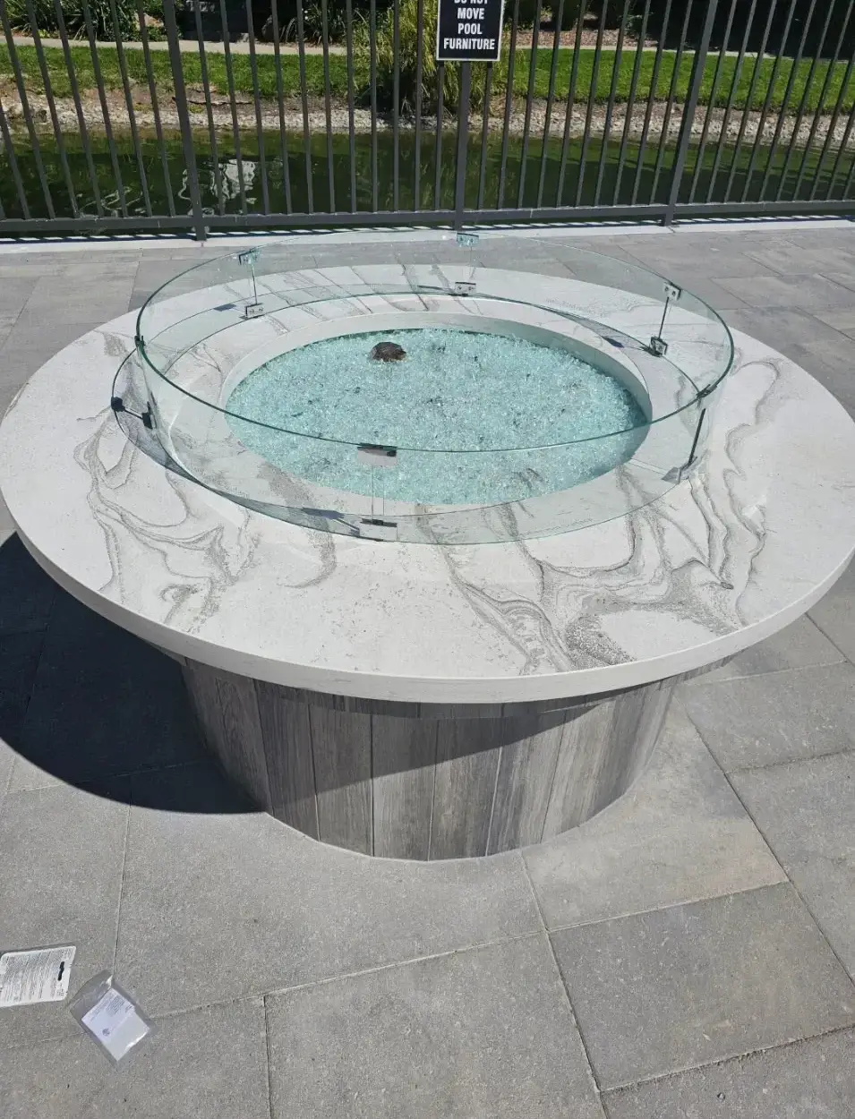 Round marble firepit with glass surround on luxury patio