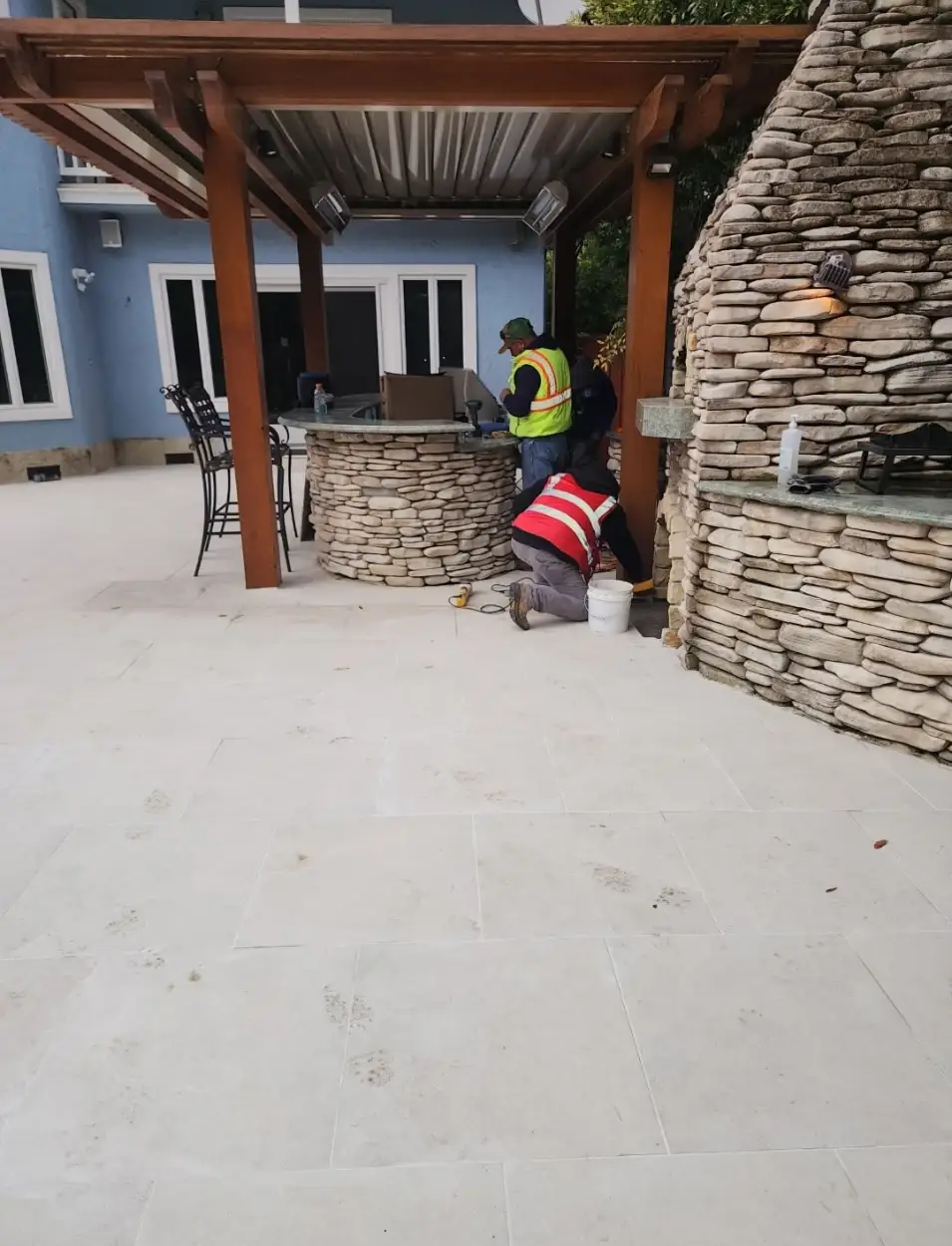 Custom wood pergola with stone bar and outdoor fireplace